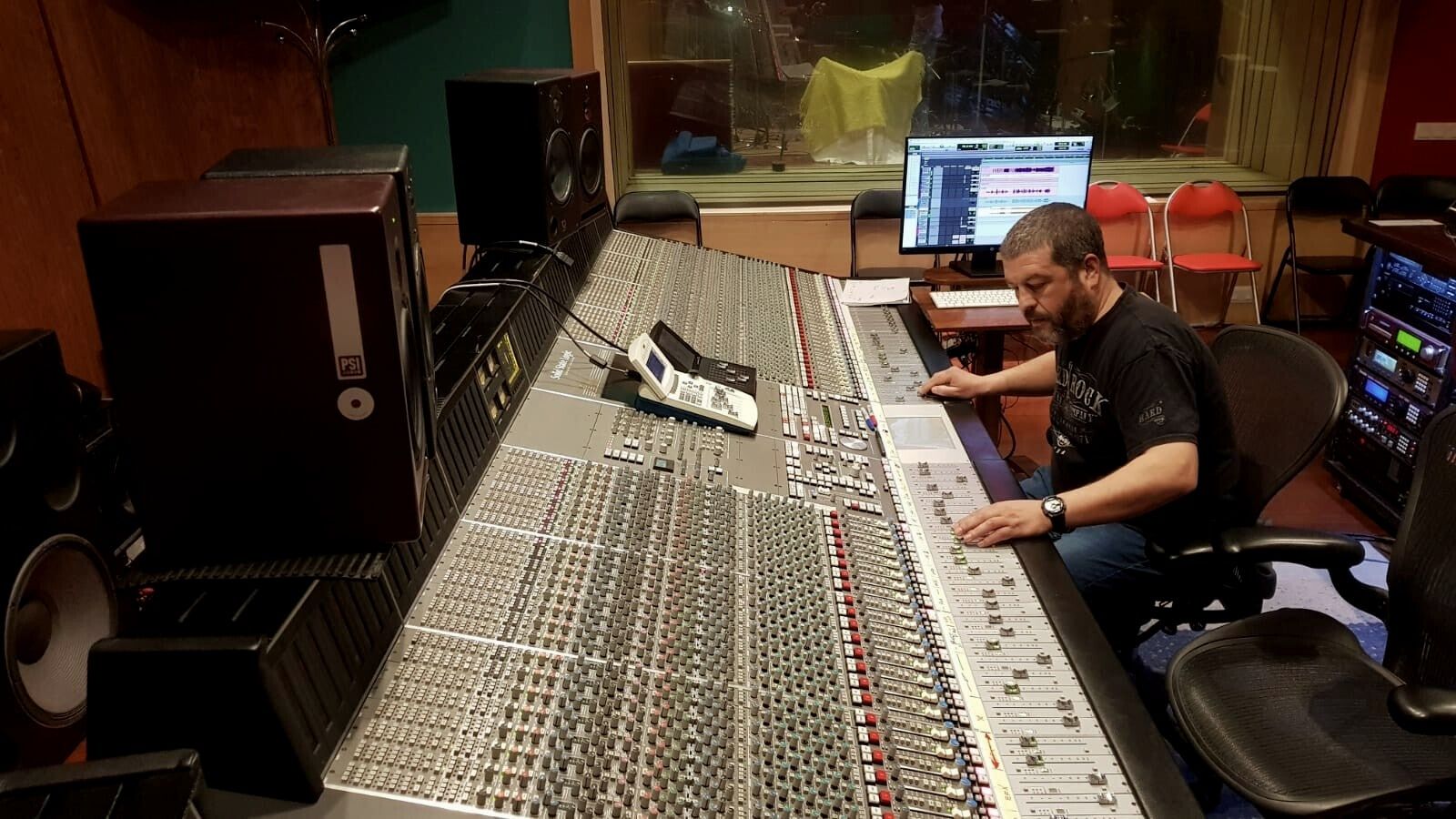 Productor trabajando en una consola de gran formato durante una sesión